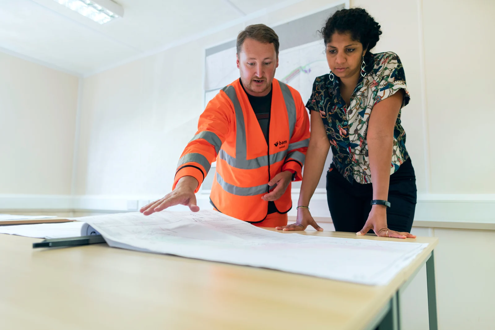 Two engineers reviewing technical plans together; illustrative photograph.